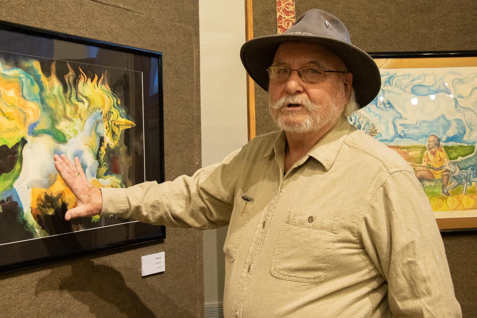 Male artist standing with painting